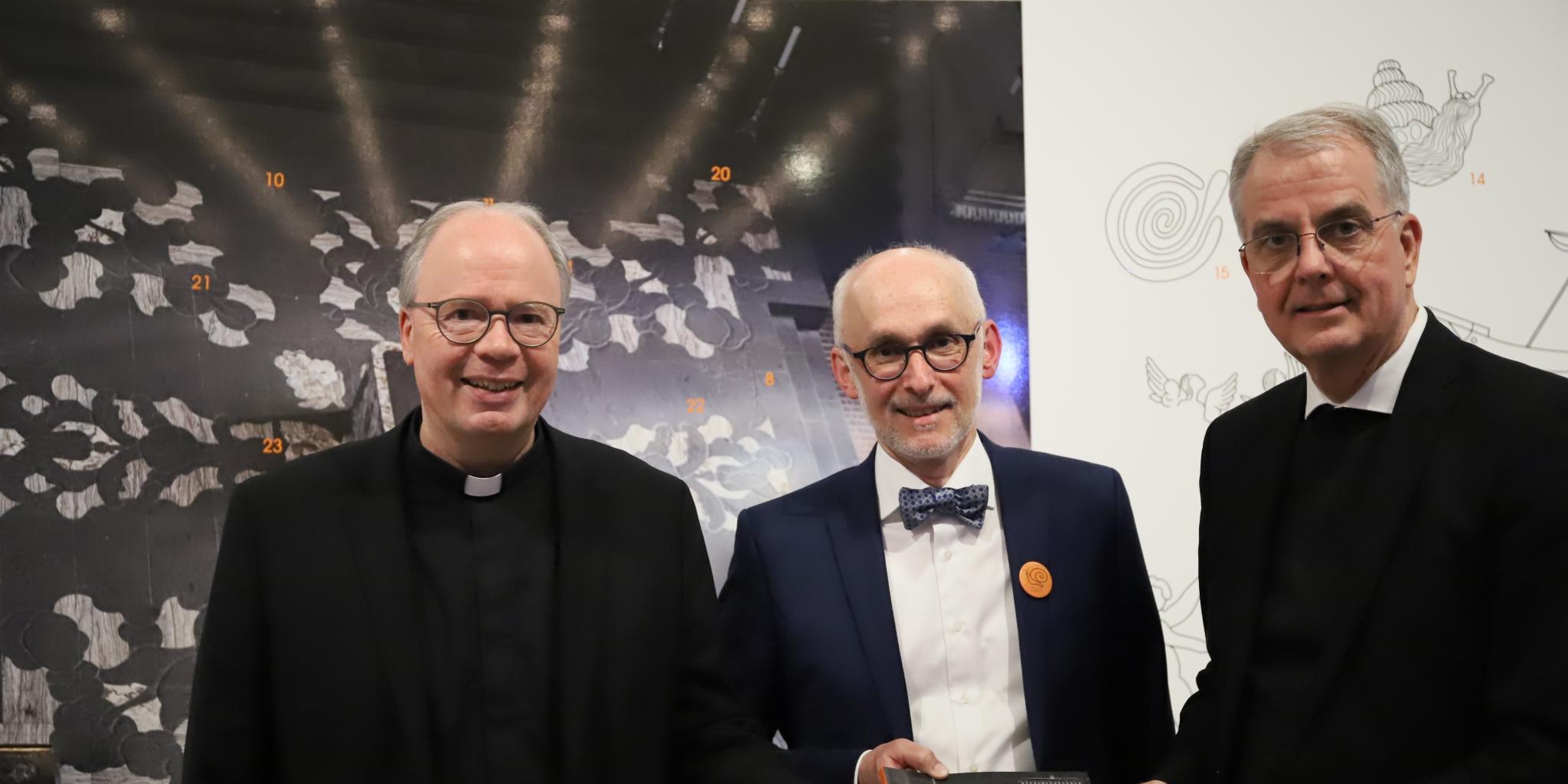 Bischof Dr. Stephan Ackermann, Markus Groß-Morgen und Dompropst Jörg Michael Peters haben die Ausstellung 'Der Trierer Dom im Wandel - was tut die Schnecke vor dem Altar' eröffnet